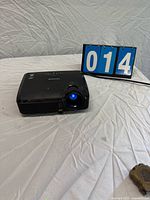 Front left view showing lens illuminated and attached power cord