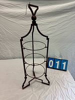 Full view of red folding metal stand with three rings