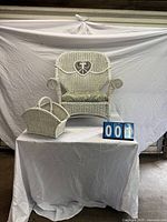 Full view of wicker armchair with cushion and matching basket