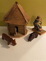 Group shot showing hut, two animal figurines, fisherman