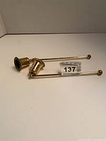Both brass candle snuffers side by side showing overall form