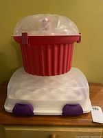 Rectangular Wilton carrier base with clear lid and purple clips; red round carrier stacked on top