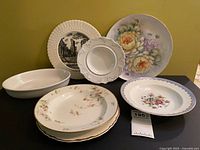 Group shot of all eight items: oval baker and seven assorted plates