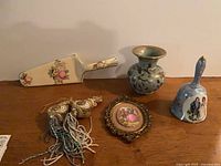 Group shot showing bell, framed picture, Fohr vase, tassels, cake server