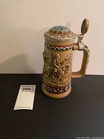 Full view of beer stein with lid and auction tag