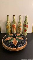 Full view of pie dish and four painted bottles