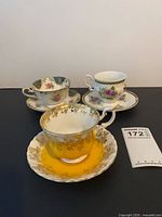 Three teacup and saucer sets standing together