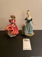 Both Royal Doulton figurines side by side with lot tag visible