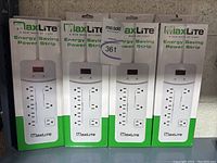 Four new MaxLite Energy Saving Power Strips in their original packaging, displaying front view of the boxes.