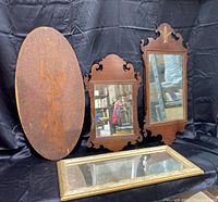 Full view of all four items: large oval etched wooden mirror, two smaller ornate wooden framed mirrors, and rectangular gold frame mirror on a black background.