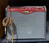 Front view of Line 6 Spider combo amplifier with instrument cable coiled on handle