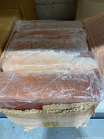 Top view of 10 wrapped rectangular Himalayan salt blocks in a box showing pink-orange crystalline texture.