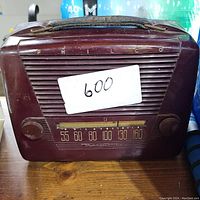 Front view of vintage Philco tube radio showing maroon casing, two knobs, and analog frequency dial with AM frequencies 55 to 160.