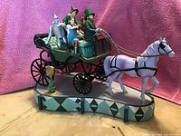 Full view of the music box showing horse-drawn carriage with four Wizard of Oz characters and ornately decorated base