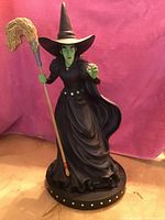 Photo of the 19-inch tall Bradford Exchange Wicked Witch of the West figurine showing full figure and colorful details against a pink background.