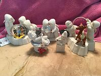 Five-piece set of Department 50 Snowbabies Wizard of Oz themed figurines arranged on a surface with a pink background.