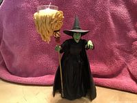 Photo of Wicked Witch of the West figurine holding a candle with flame-shaped holder