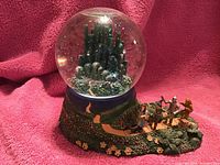 Photo of the Wizard of Oz themed San Francisco music snow globe showing the globe with Emerald City and character figurines on the base