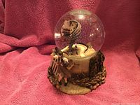 Large Wizard of Oz themed water globe with tornado and house inside, Dorothy figure outside, and sculpted base with vines and roots.