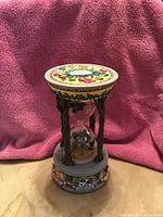 Full view of the ornate hourglass music box with Wizard of Oz themed decorations and character details.