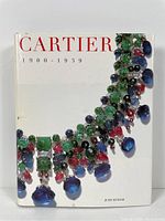 Front cover of the Cartier Jewelry Reference Book featuring the title and an image of a colorful Cartier necklace.