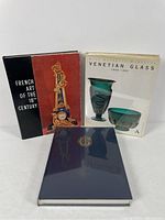 Three decorative art reference books arranged standing and lying on a flat surface, showing the front covers.