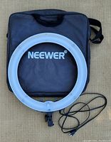 Full top-down view of Neewer 18 inch ring light and carrying case with power cable coiled.
