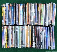 Two rows of DVD cases laid out flat, front covers visible, showing a variety of movies including Avatar, Gladiator, Sideways, and others.
