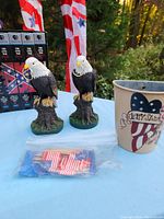 Patriotic lot table with two eagle figurines, PBS Civil War VHS tapes, and decorative patriotic cup