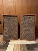 Pair of vintage AR Inc speakers showing front view with wooden frames and woven fabric grills.