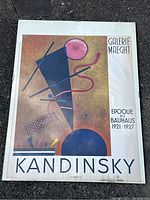 Full view of the Kandinsky gallery poster showing artwork and text with visible wear and water damage on edges.