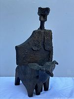 Front-left view of sculpture showing cowboy figure mounted on bull.