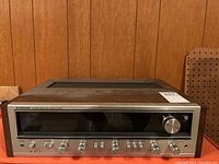 Front view of receiver powered off, showing brushed metal faceplate and control knobs