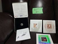 Full view of Canada Post 2000 Millennium Keepsake with three souvenir stamps and quarter in presentation box placed on leather background.