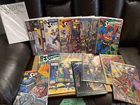 Photo showing a spread of various DC Comics mostly featuring Superman and World's Finest titles, some in protective sleeves, arranged on a dark surface.