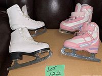 Two pairs of kids ice skates side by side. Left pair is white Softec figure skates, size 9Y. Right pair is pink and white Winnwell hockey skates, size 10Y. Both with silver blades.
