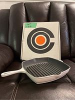 White Le Creuset cast iron skillet grill 10.25 inch with original box showing logo.