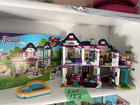 Complete LEGO Friends 41449 Andrea's Family House set displayed assembled alongside original box and heart-shaped pool accessory.