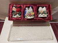 Set of three musical Christmas ornaments featuring pairs of birds, hand-painted with rose patterns in red satin-lined box with plastic cover removed