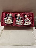Box set of 3 hand painted musical snowman ornaments in satin-lined box.