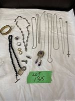 Full display of all silver and gold filled jewelry including necklaces, rings, earrings, bracelet, and pendant on white cloth.