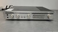 Front view of Luxman stereo tuner amplifier showing controls, knobs, tuning dial, and power button