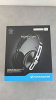Photo of the original Sennheiser MOMENTUM headphones box, showing branding, product name, and product image.