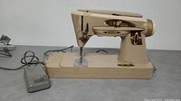 Side view of beige Singer 503J sewing machine including base and power cord