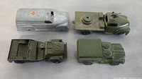 Top angle view showing all 4 metal toy trucks with worn paint and detailing