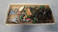 Full lot overview showing two Dinky airplanes, multiple toy soldiers, and vehicles in a box.