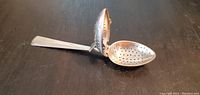 Photo showing the egg spoon open with the hollow perforated head fully extended.
