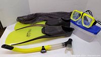 Photo showing the lime green snorkeling flippers, yellow and black snorkel mask with green frame, lime green snorkel, storage case and mesh bag