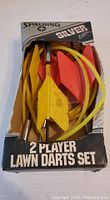 Overall view of the vintage Spalding Silver 2 player lawn darts set in original box showing yellow and red darts and yellow rings.
