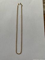 Full length of rope chain laid flat on white background